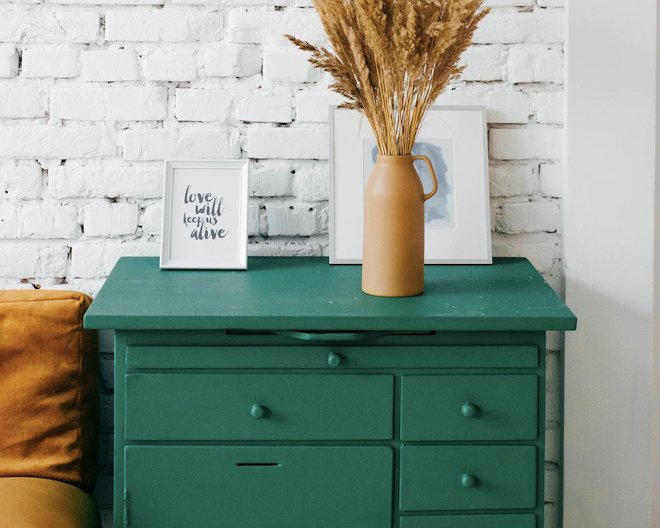 a green drawer with a brown flower vase untop of it