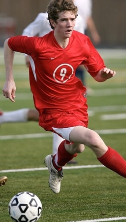 a male football player putting on a red jersey during a game